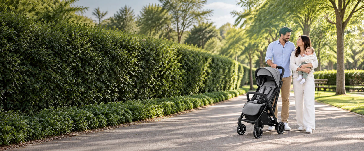 Parents with their baby beside a compact stroller on a park path
